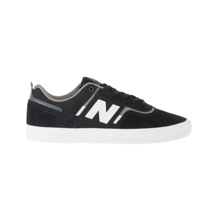 Black and white sneaker with a large \“N\“ logo on the side, featuring a suede upper and a white rubber sole.