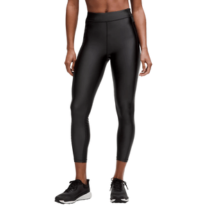 A person is wearing shiny black high-waisted leggings paired with black running sneakers.