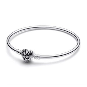 A silver bangle bracelet featuring a heart-shaped charm with star and moon cutouts.