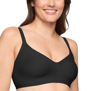 A woman is wearing a black, seamless, wire-free bra with adjustable straps. She is smiling and the focus is on the fit and design of the bra.