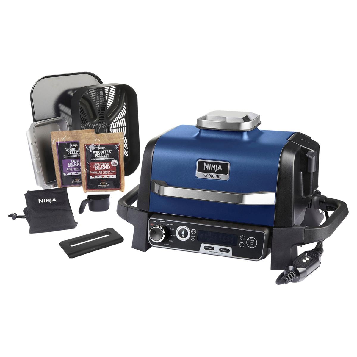 Ninja Woodfire outdoor grill in blue with accessories including woodfire pellets, grill tray, and measuring cup.