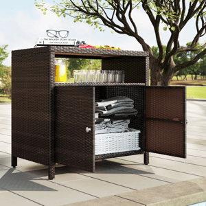 Poolside wicker cabinet with open shelving displays folded towels, glasses, books, and a pitcher of juice under a tree.