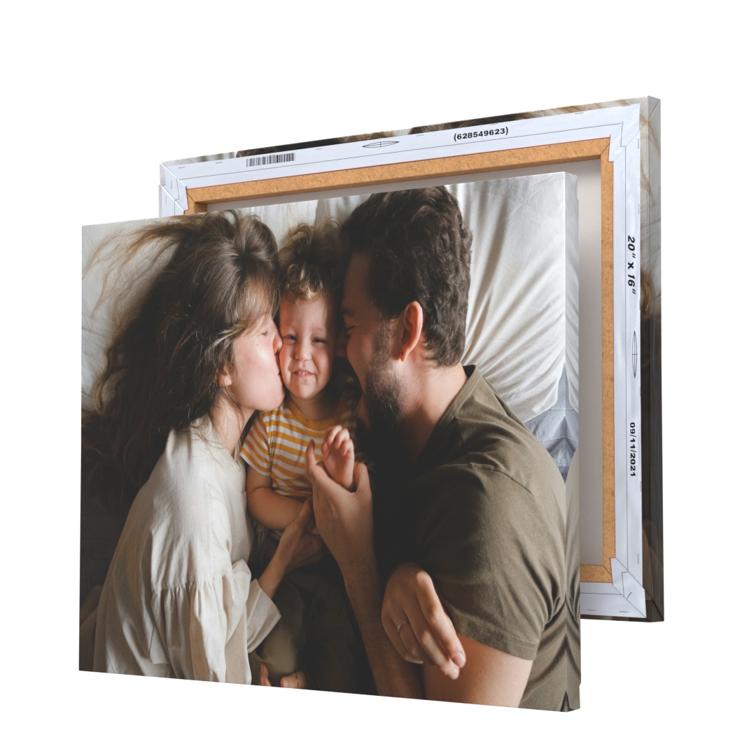 A canvas print displays a family of three sharing a joyful moment. The canvas is shown with dimensions 20x16 inches, backed by a wooden frame.