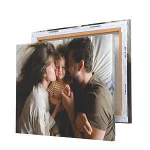 A canvas print displays a family of three sharing a joyful moment. The canvas is shown with dimensions 20x16 inches, backed by a wooden frame.