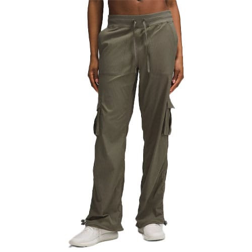 A person wearing olive green cargo pants with a drawstring waist and adjustable cuffs, paired with white sneakers.