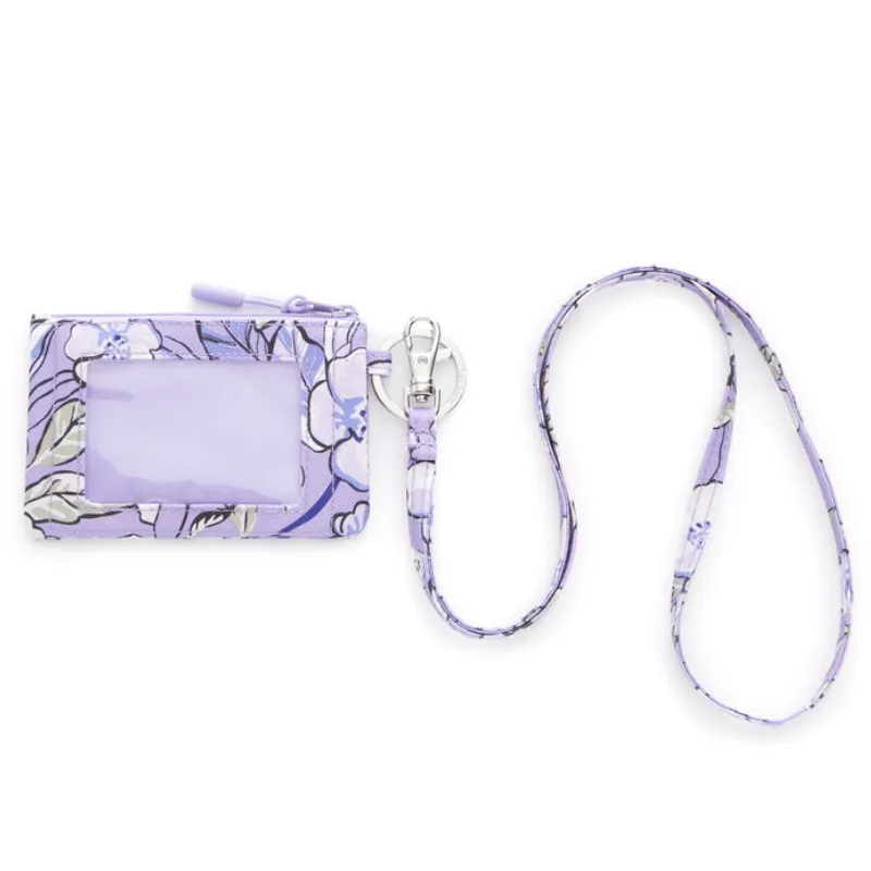 A Vera Bradley Zip ID Case in lavender floral pattern features a clear ID window, zipper closure, and an attached lanyard with a swivel clasp.
