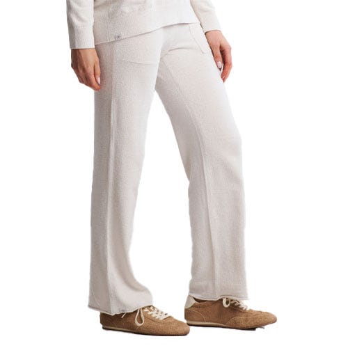 A person is wearing loose-fitting, white pants paired with brown shoes, suitable for a casual or cozy look.