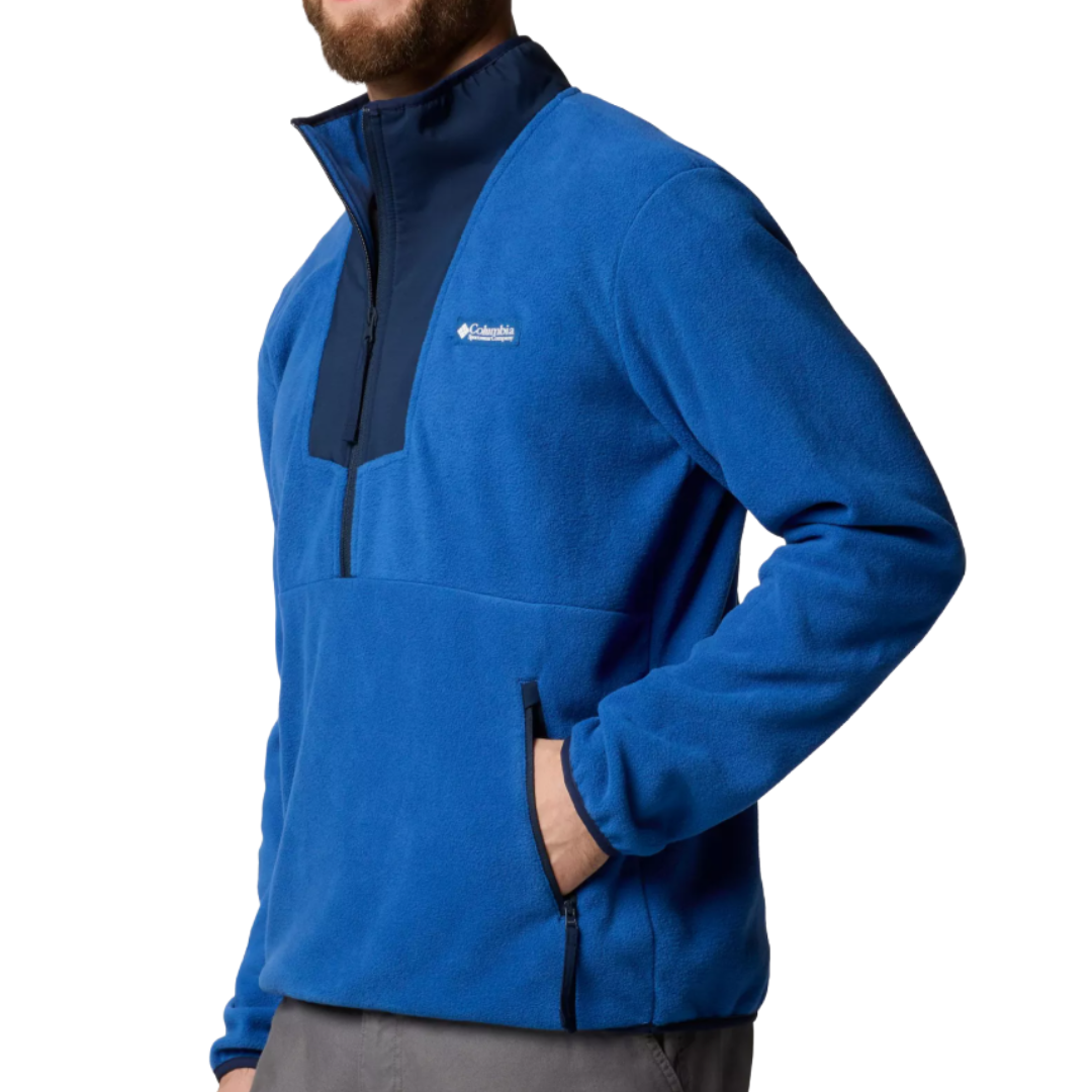 A man is wearing a blue Columbia quarter-zip fleece jacket with a high collar and zippered pockets.