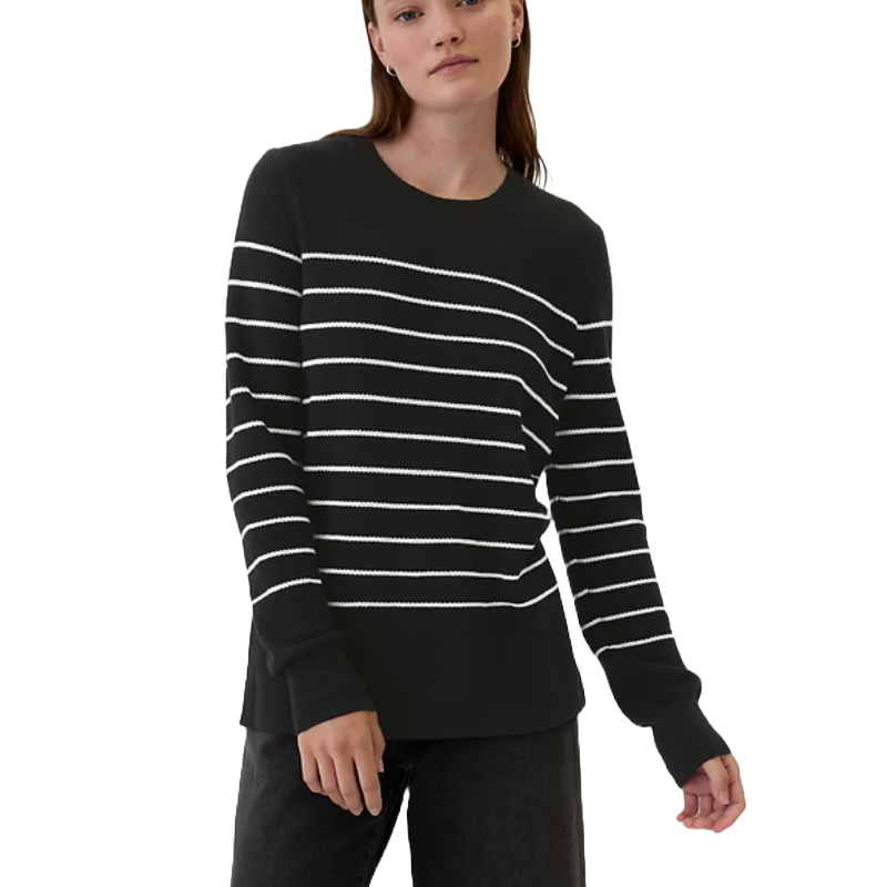 A black sweater with white horizontal stripes, worn by a model with long sleeves and a straight hem.