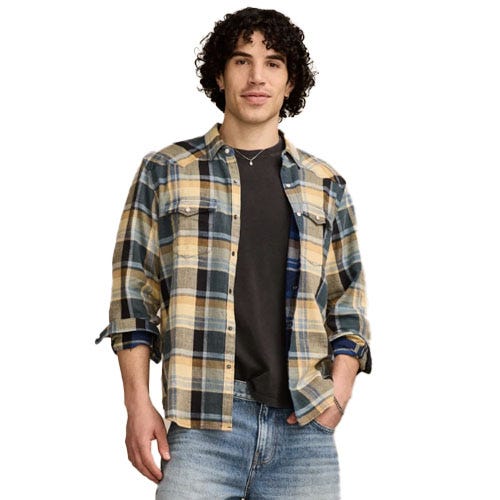 A man is wearing a plaid flannel shirt over a dark t-shirt paired with blue jeans.