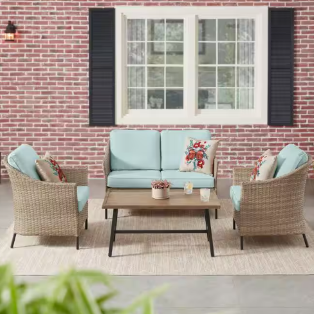 Outdoor patio furniture set with a blue cushioned loveseat, two matching armchairs, and a rectangular coffee table.