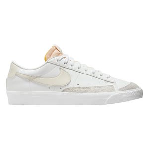 Nike Men's Blazer '77 Vintage Shoes feature a classic low-top design with a white leather upper, off-white suede accents, a cream-colored Nike swoosh, and a retro-style yellow tongue. They have a minimalistic, timeless look with a textured white rubber sole.