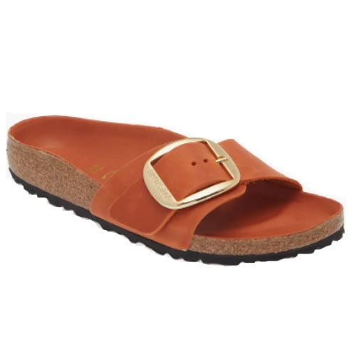 A single-strap sandal with an oversized adjustable buckle, featuring a cork footbed and a textured black outsole.