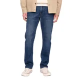 A person is wearing blue straight-leg jeans paired with white sneakers and a beige jacket.
