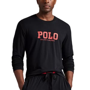 A man wearing a black long-sleeve shirt with \“POLO Ralph Lauren\“ printed in red on the front, paired with matching black drawstring pants.