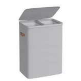 A rectangular, dual-compartment laundry hamper with a hinged lid, light gray fabric exterior, and brown side handles.