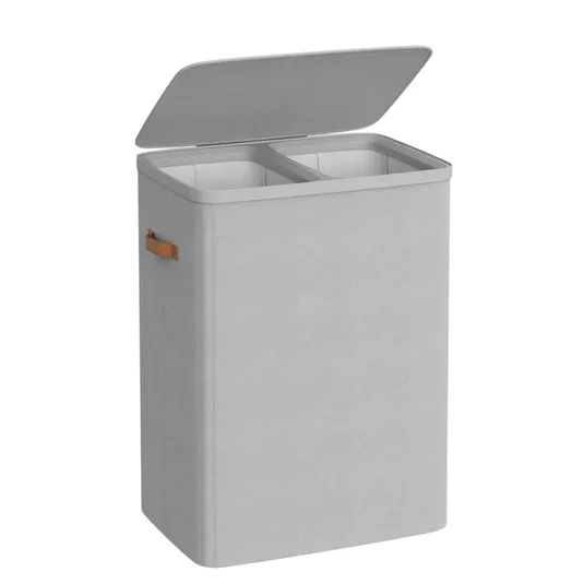 A rectangular, dual-compartment laundry hamper with a hinged lid, light gray fabric exterior, and brown side handles.