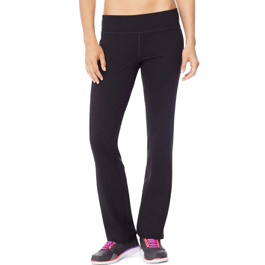 Black yoga pants with a wide waistband, paired with black athletic shoes featuring pink laces and white soles.