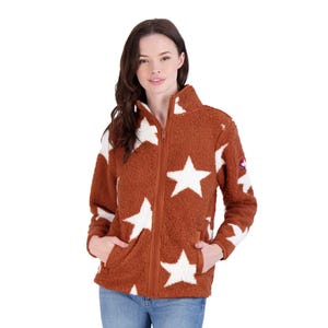 A woman models a brown fleece jacket with a zipper, featuring large white stars and a patch on the sleeve, paired with blue jeans.
