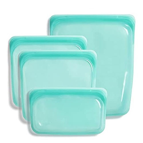 Four aqua-blue silicone reusable storage bags of varying sizes for food storage.