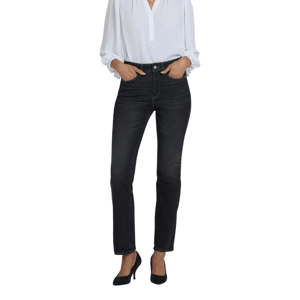 A woman wearing a white long-sleeve blouse, dark high-waisted jeans, and black heels.