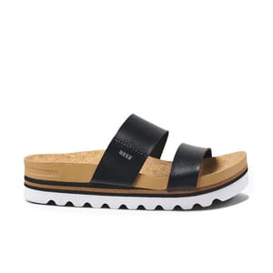 The Reef Cushion Vista Hi Sandals feature a black dual-strap design with a tan cork footbed and a white platform sole with wave-like tread for added grip and style.