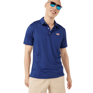 A person wearing a blue polo shirt with a small flag emblem and beige shorts, accessorized with blue-tinted sunglasses.