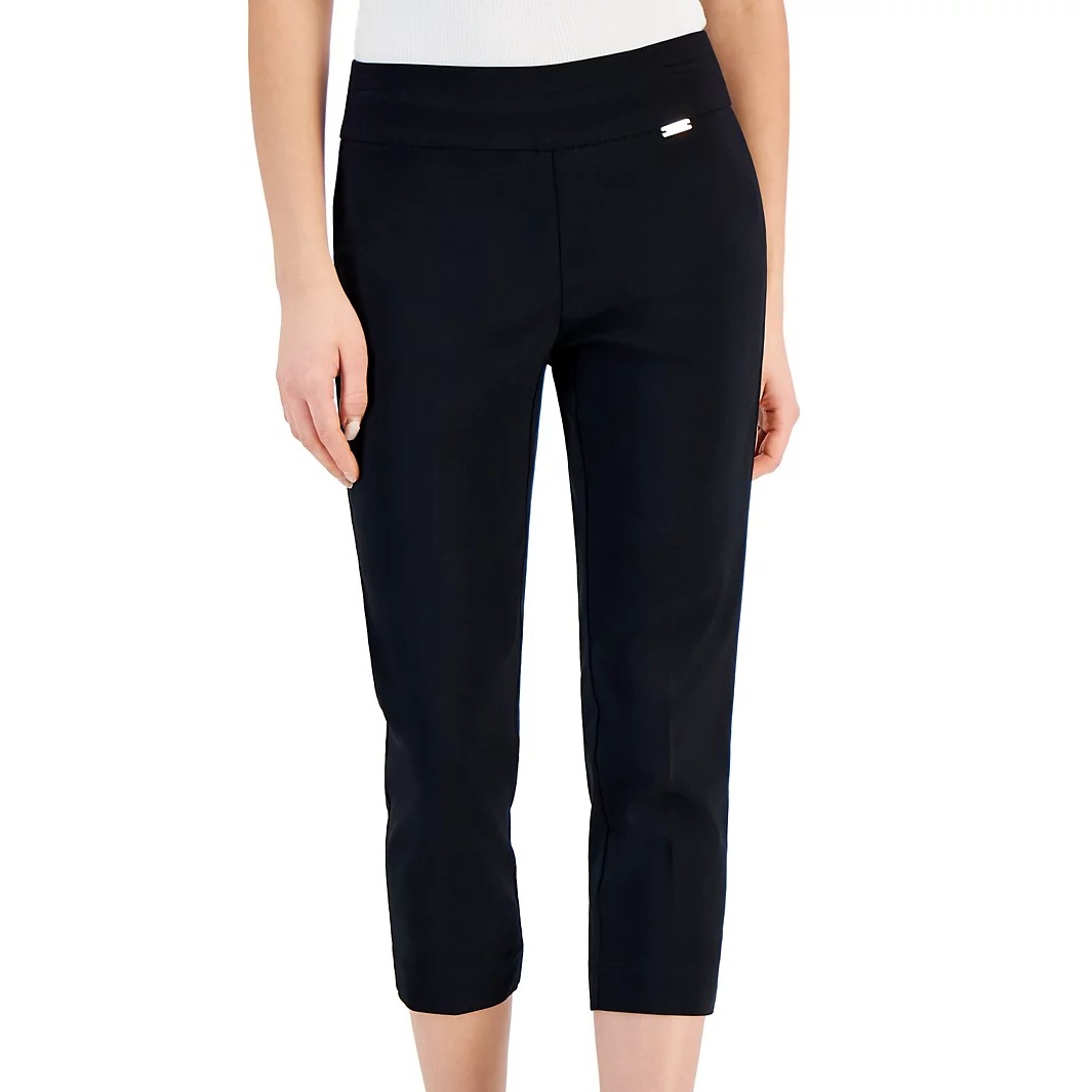 Black capri pants with a slim fit and a small decorative metal detail near the waistband, paired with a white top.