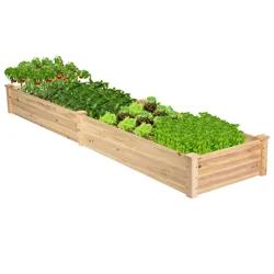 A wooden raised garden bed with compartments, filled with various green plants and some red tomatoes, arranged in a long rectangular shape.