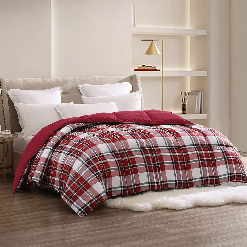 A bed features a red and white plaid comforter with several white pillows against a beige headboard. A gold floor lamp and minimalist shelves in the background add modern decor elements to the room.
