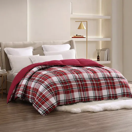 A bed features a red and white plaid comforter with several white pillows against a beige headboard. A gold floor lamp and minimalist shelves in the background add modern decor elements to the room.