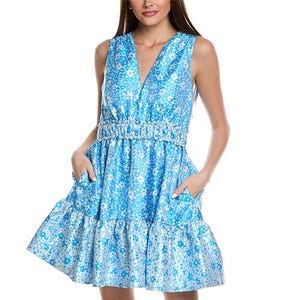 Blue sleeveless mini dress featuring a vibrant floral pattern, deep V-neckline, ruched waistband, and a tiered ruffled hemline.