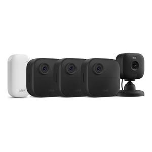 A set of Blink security cameras and a module, including three black outdoor cameras and one black indoor camera on a stand, along with a white sync module.