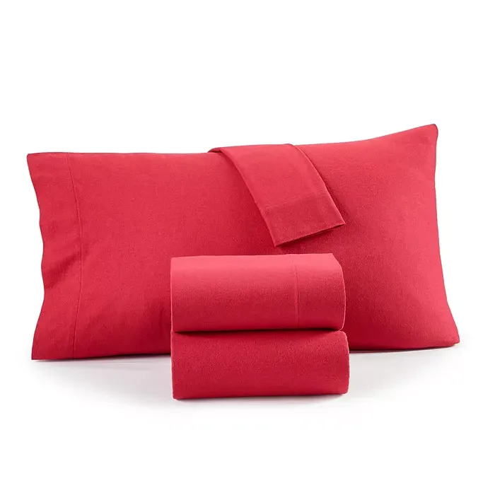 Red bedding set including two pillowcases and folded sheets.