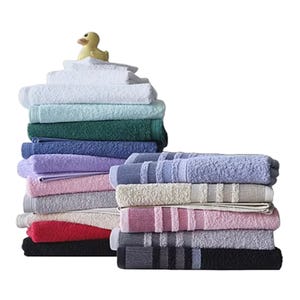A stack of colorful folded towels with a small rubber duck on top.