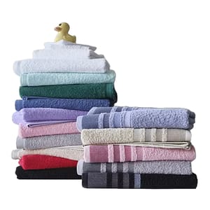 A stack of colorful folded towels with a small rubber duck on top.