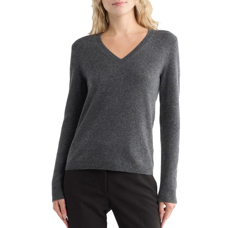 A woman is wearing a gray V-neck sweater with long sleeves, paired with black pants.