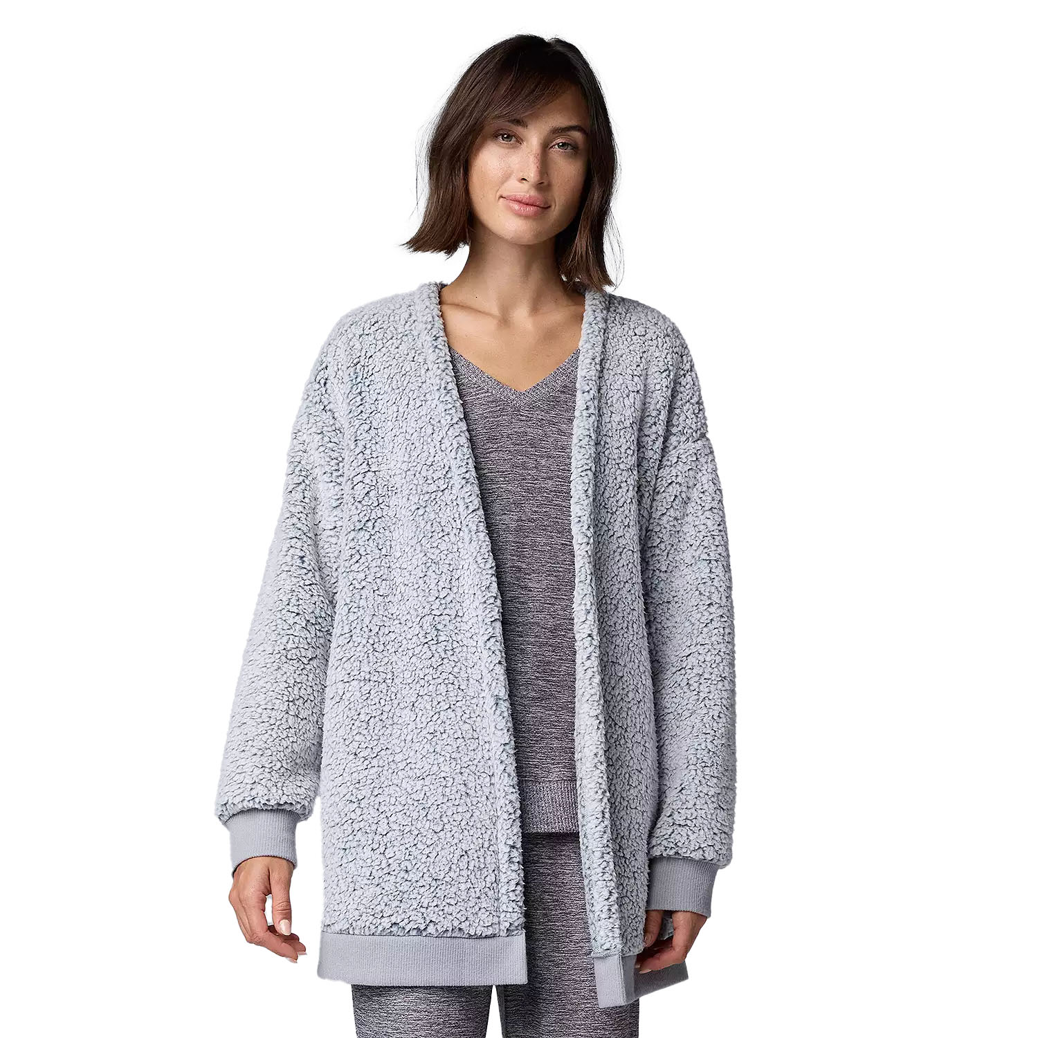 A plush, long-sleeve cardigan with ribbed cuffs and an open front, presented in a light grey color. The model is wearing a matching grey loungewear set underneath.