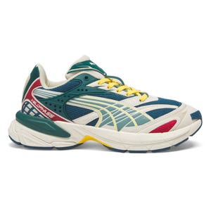 Multicolored sneaker featuring a mix of teal, white, yellow, red, and blue with a chunky sole and yellow laces, branded as \“VELOPHASIS.\“