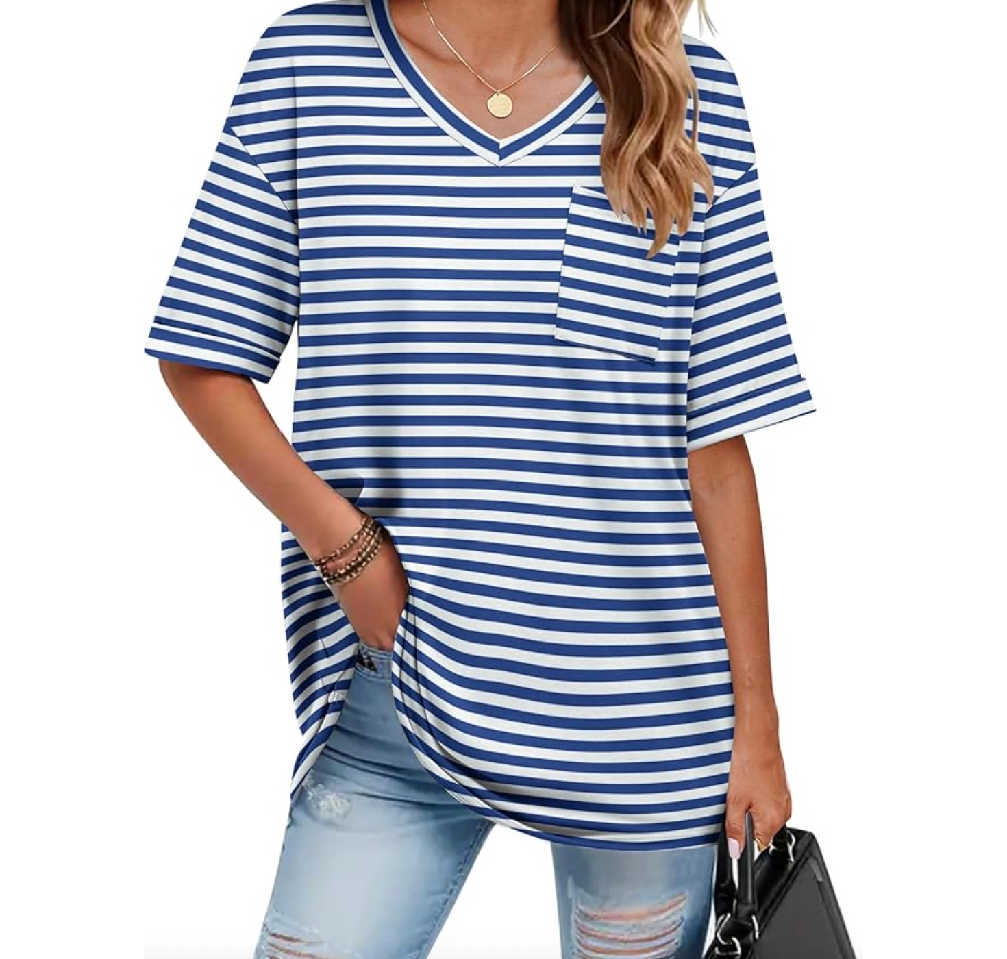 A woman is wearing a blue and white striped short-sleeve V-neck shirt with a pocket and light blue ripped jeans, carrying a black handbag. She has on bracelets and a necklace with a round pendant.