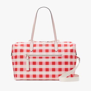 A red and white checkered duffle bag with tan handles and a detachable shoulder strap.