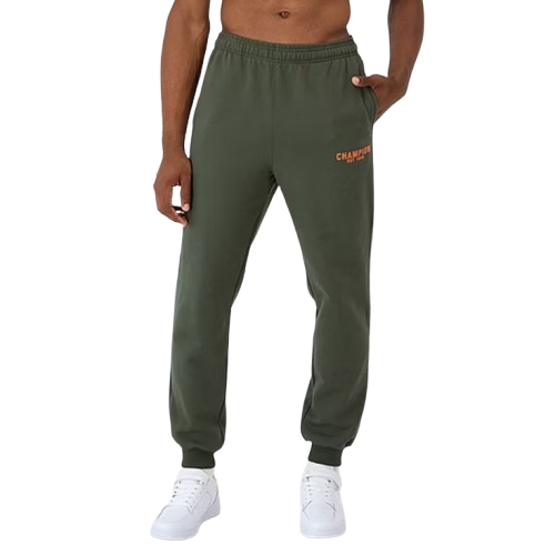 Green Champion fleece joggers with an orange logo, featuring an elastic waistband and cuffs. The joggers are paired with white sneakers.