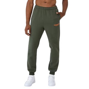 Green Champion fleece joggers with an orange logo, featuring an elastic waistband and cuffs. The joggers are paired with white sneakers.