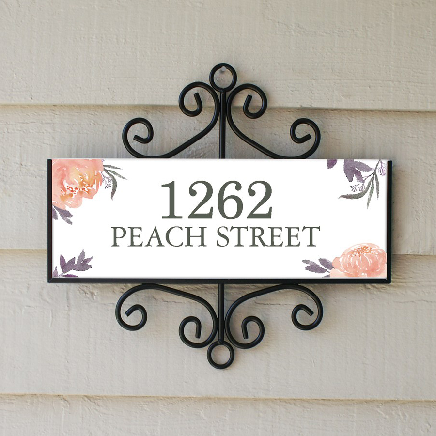 A decorative address plaque with the text \“1262 Peach Street\“ features floral designs and ornate metal framing.