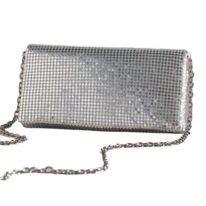 Rectangular silver mesh clutch with a chain strap, featuring a shimmering, textured exterior.