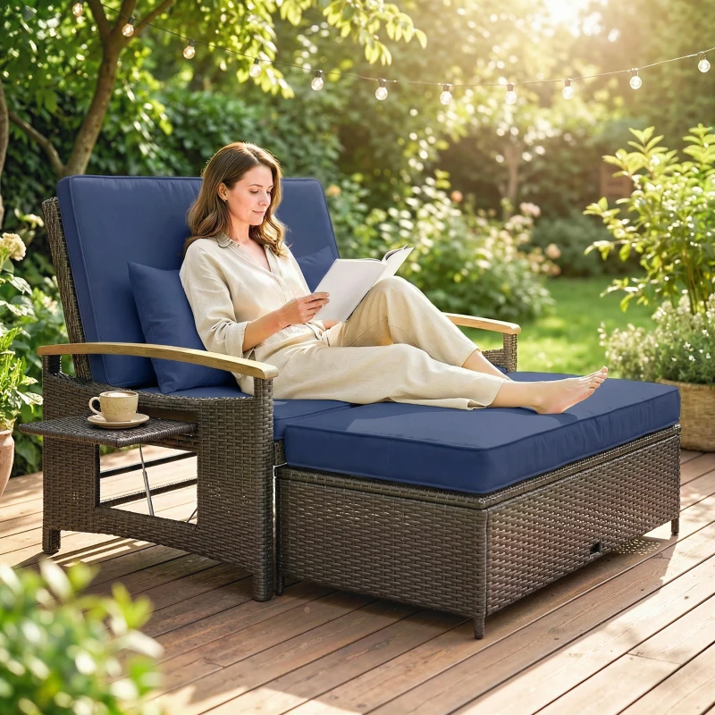 A person relaxes on a large outdoor wicker lounge chair with blue cushions, accompanied by a small side table holding a coffee cup. The setting is a lush garden with string lights overhead.