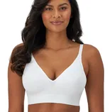 A woman is wearing a white wireless bra with thin straps and a V-neck design.