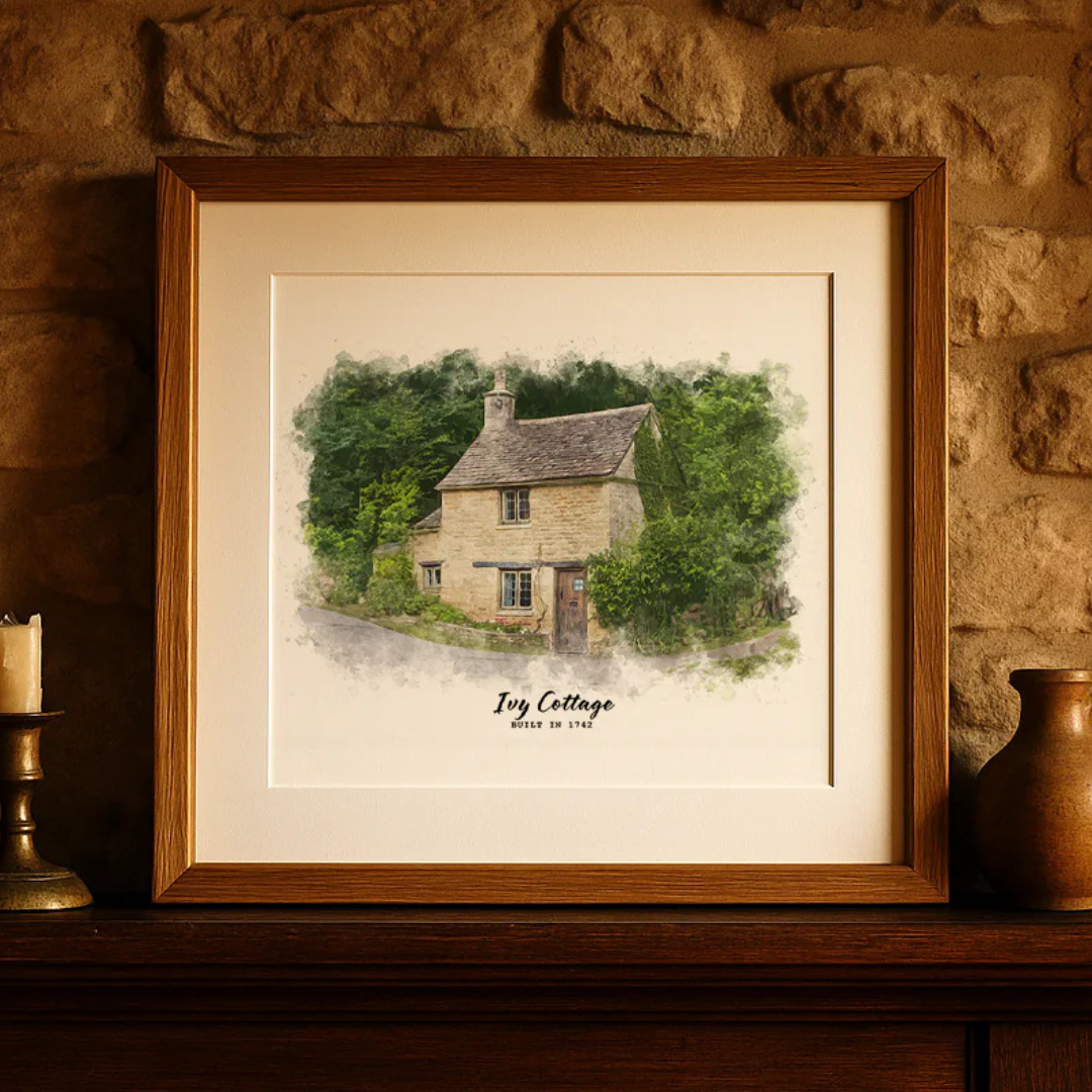 Framed watercolor illustration of a cottage titled \“Ivy Cottage, Built in 1782,\“ displayed on a stone wall shelf.