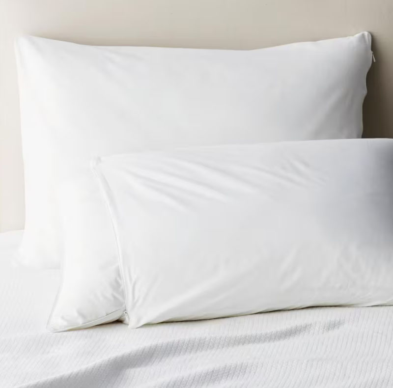 White pillow protector with a zippered closure, designed to cover and protect pillows.