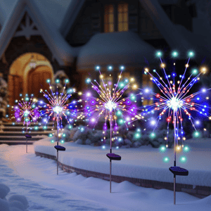 Solar-powered LED garden lights shaped like fireworks display colorful lights outdoors in a snowy setting, lining a pathway to a house.